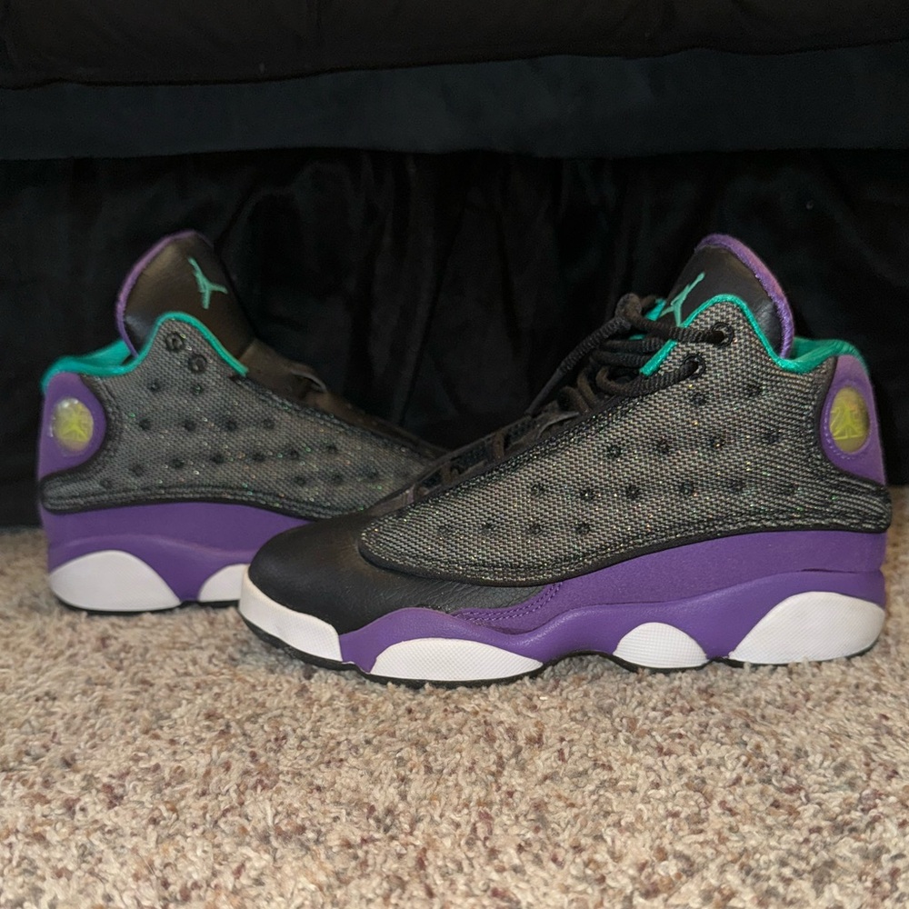 Air Jordan 13 Retros in a black, purple, and teal colorway